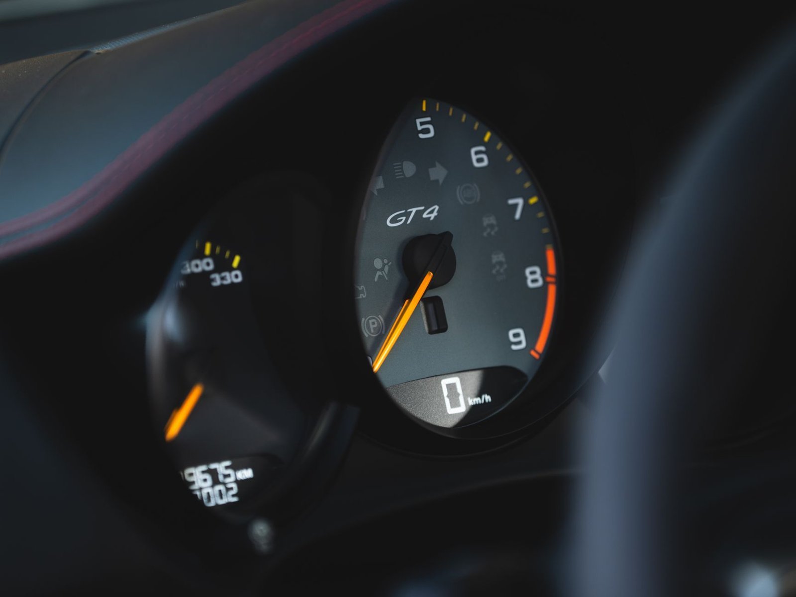 Detailed view of a GT4 car speedometer on a dashboard, focusing on speed measurement.