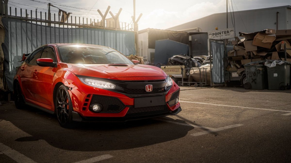 Dynamic shot of a red Honda Civic Type R parked in an urban Cyprus environment during the day.