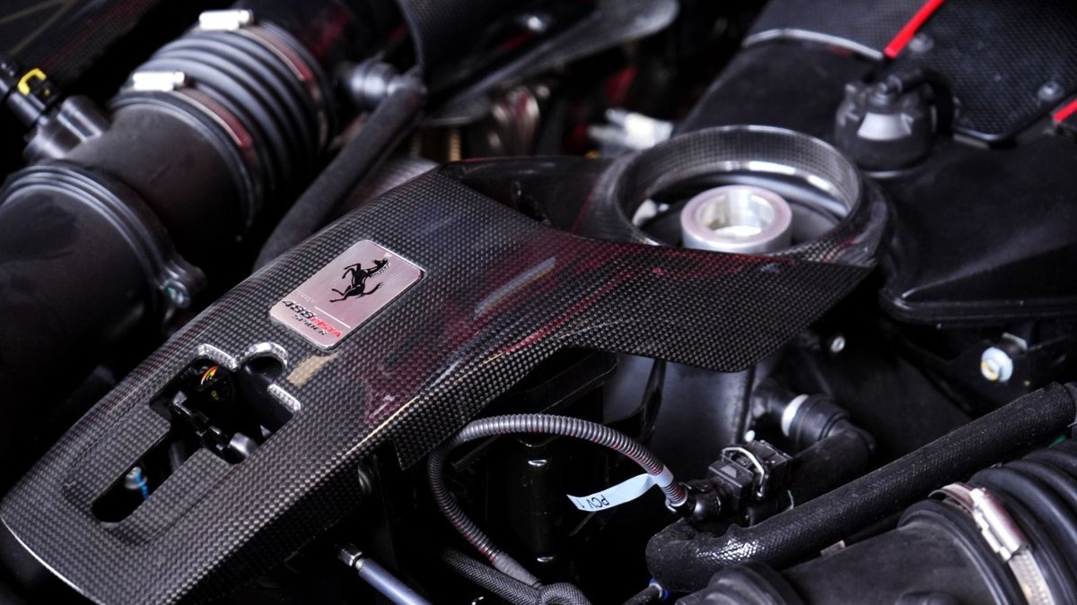 Detailed view of a high-performance car engine with sleek carbon fiber components.