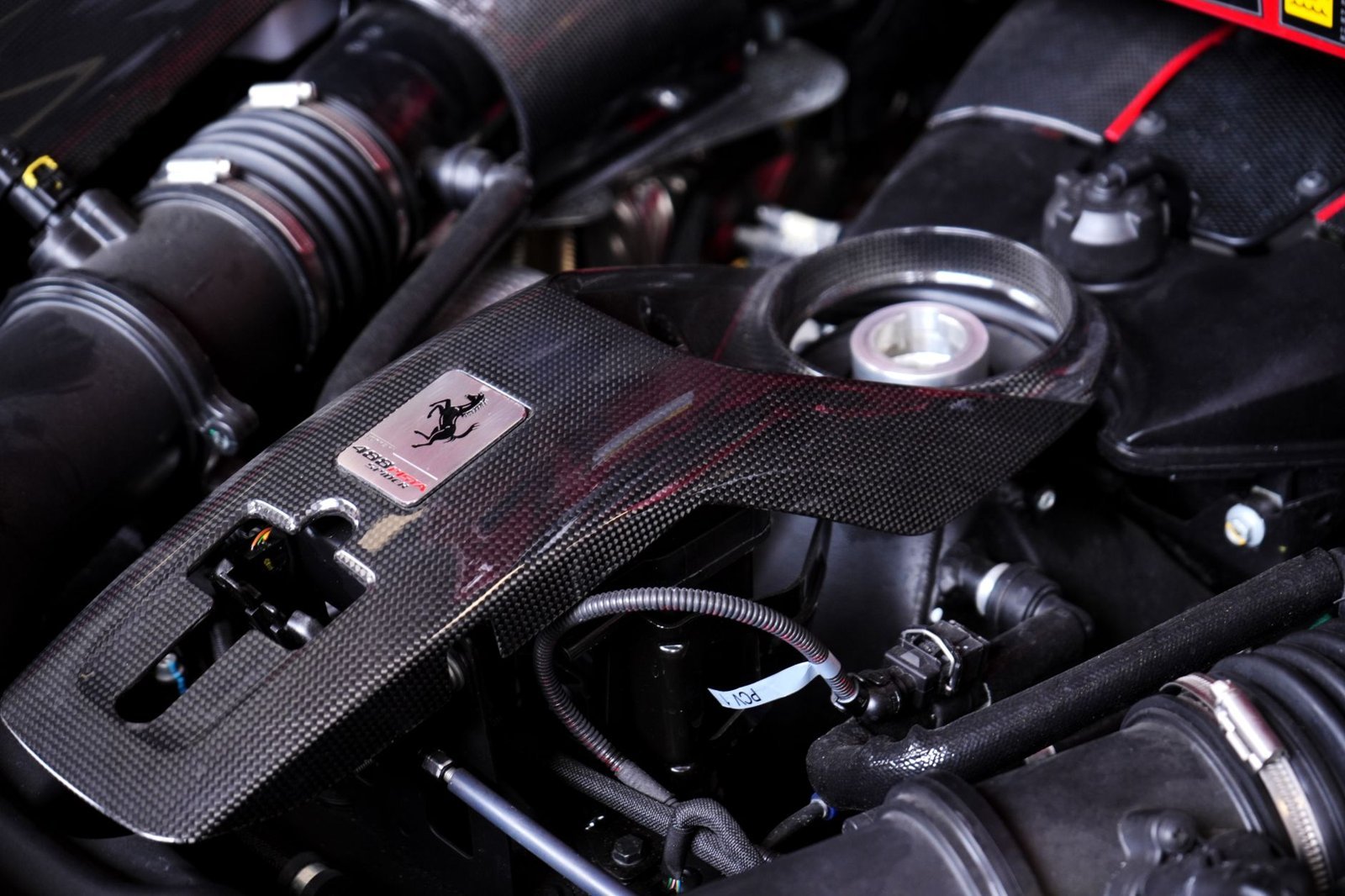 Detailed view of a high-performance car engine with sleek carbon fiber components.
