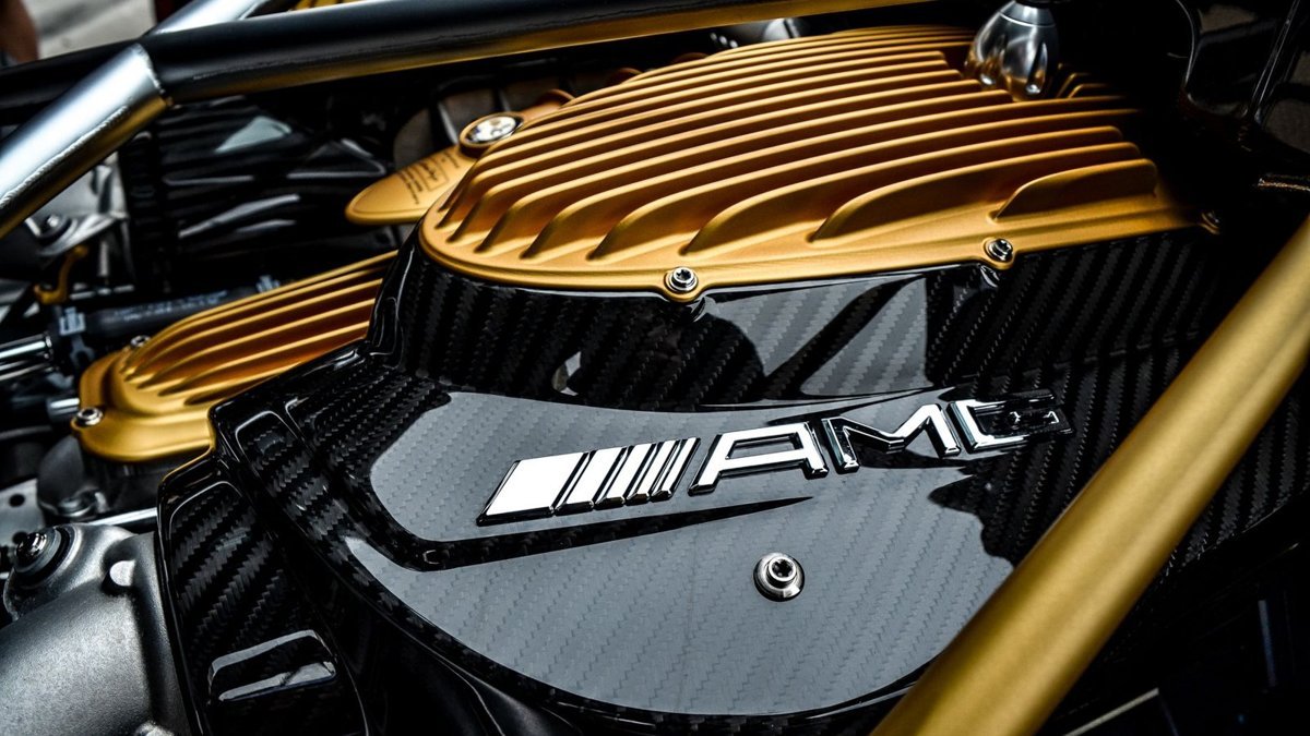 Close-up of a luxury car's engine featuring carbon fiber and gold accents, showcasing high-end design.