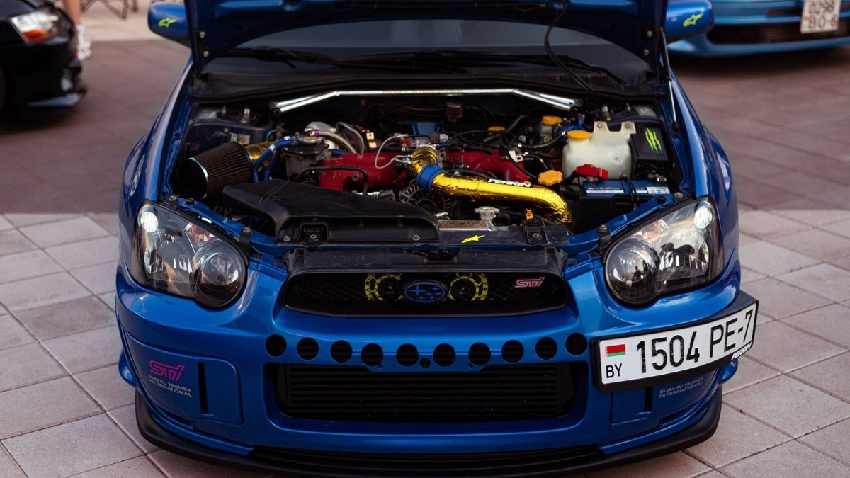 Blue Subaru Impreza STI with the bonnet raised, showing the EJ boxer engine bay