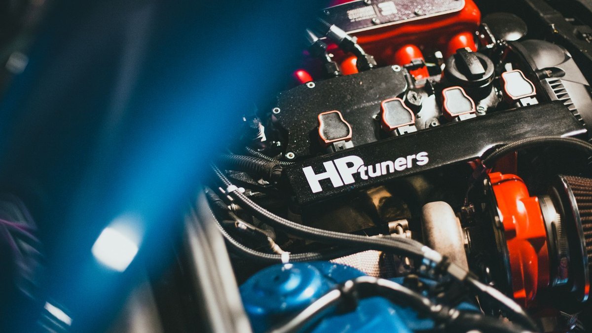 Dynamic close-up of a modern car engine featuring HP Tuners branding, showcasing automotive technology.