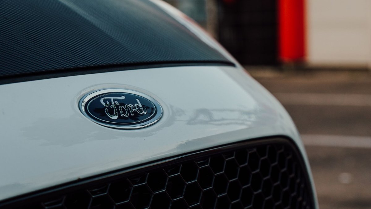 Detailed close-up image showcasing a white Ford car emblem on the vehicle's grille.